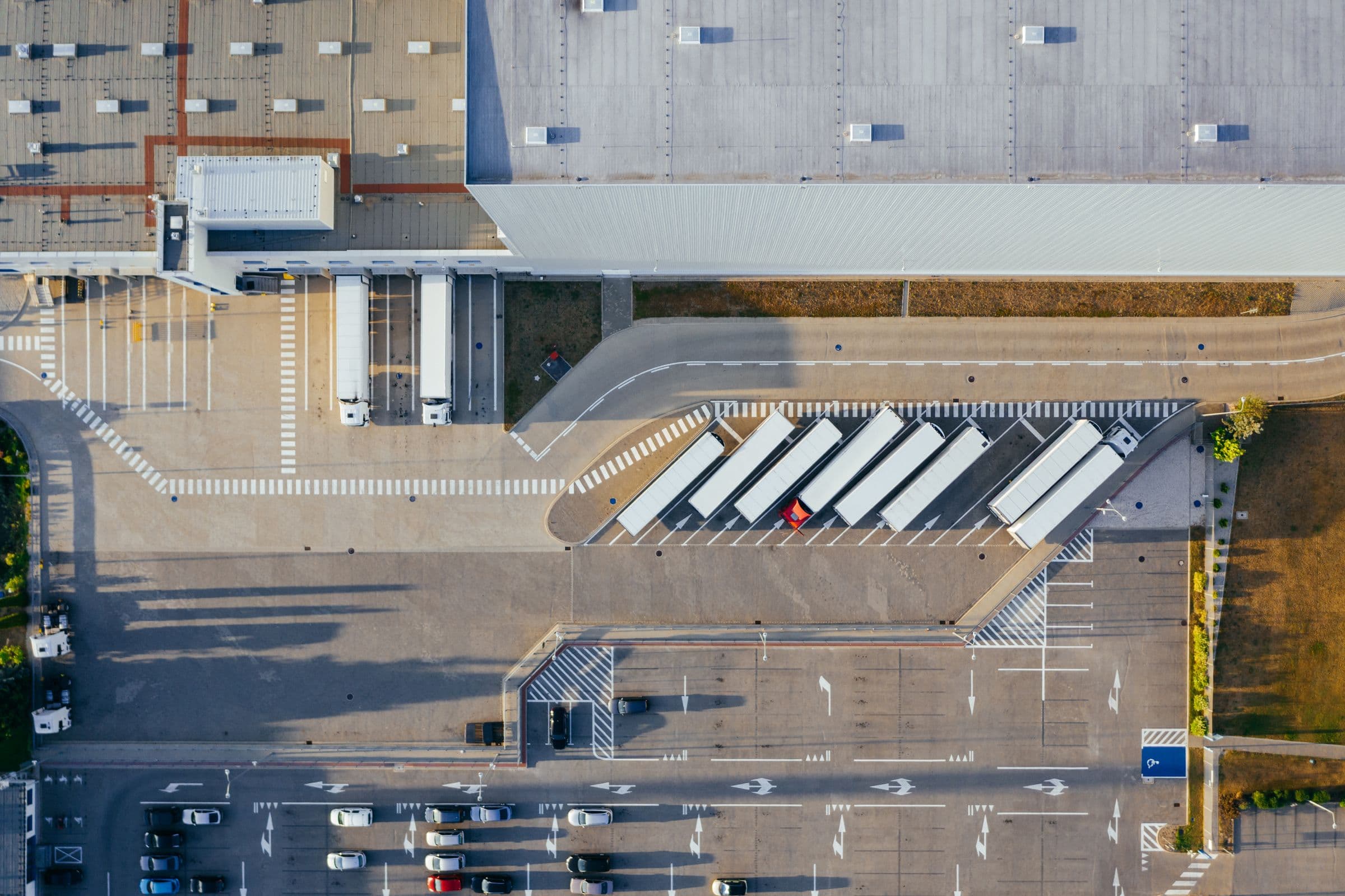 Aerial view of a distribution center with trucks at the loading docks